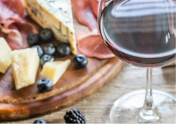 Malbec wijn op een kaasplank met bramen en blauwe bessen